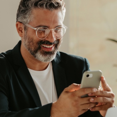 Man smiling looking at phone in office