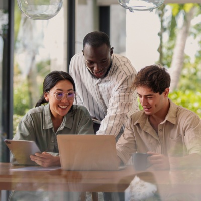 three people in office looking at computer